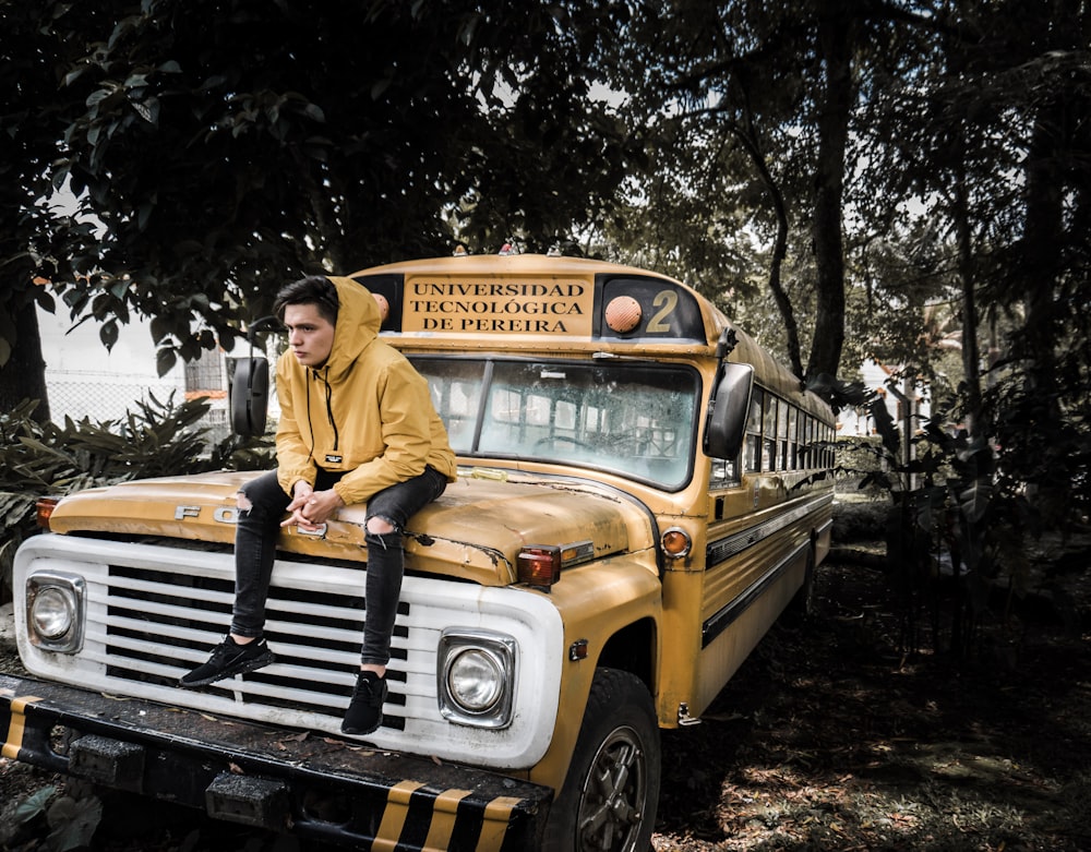 man in yellow dress shirt sitting on yellow and black jeep wrangler