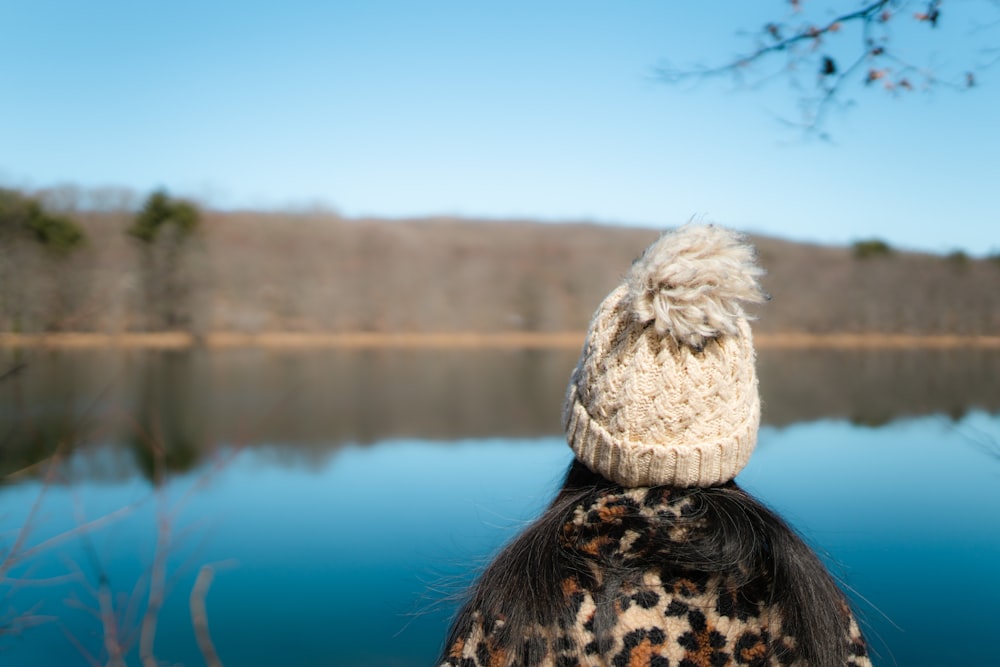 person wearing white knit cap and black and brown leopard print shirt