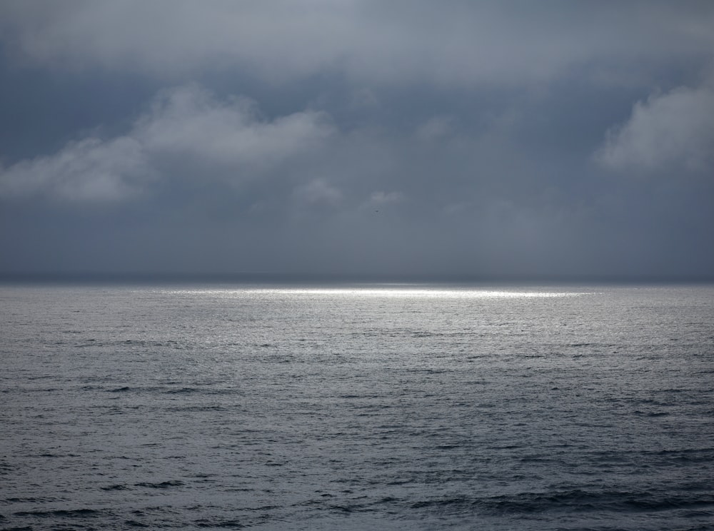 body of water under cloudy sky during daytime