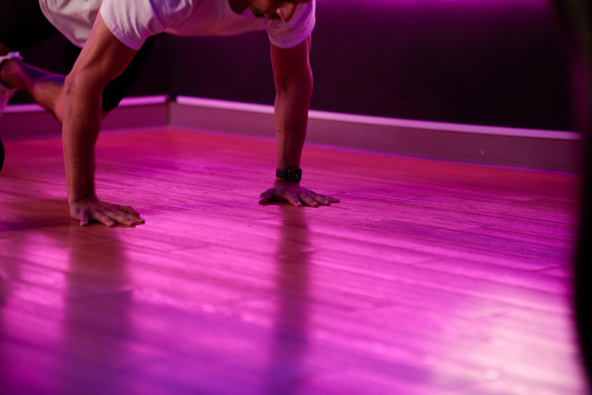 man in white tank top and black shorts doing push up