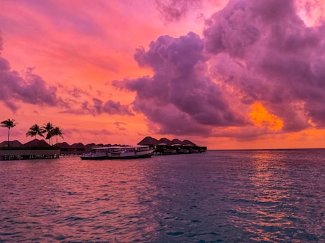 A vibrant sunset over the turquoise waters of Morro de São Paulo with a sleek lancha cruising by.
