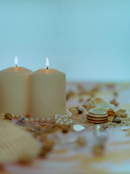 Elegant meditation candles casting a warm glow on a nude pink tray surrounded by calming crystals.