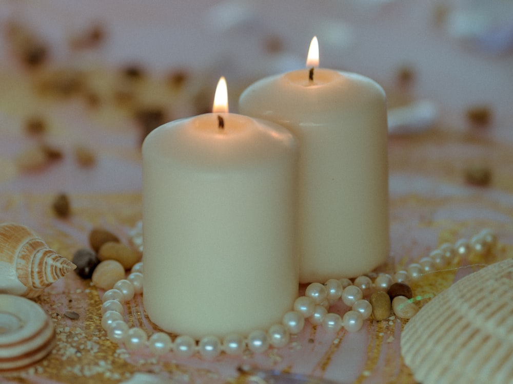 white pillar candle on white table cloth