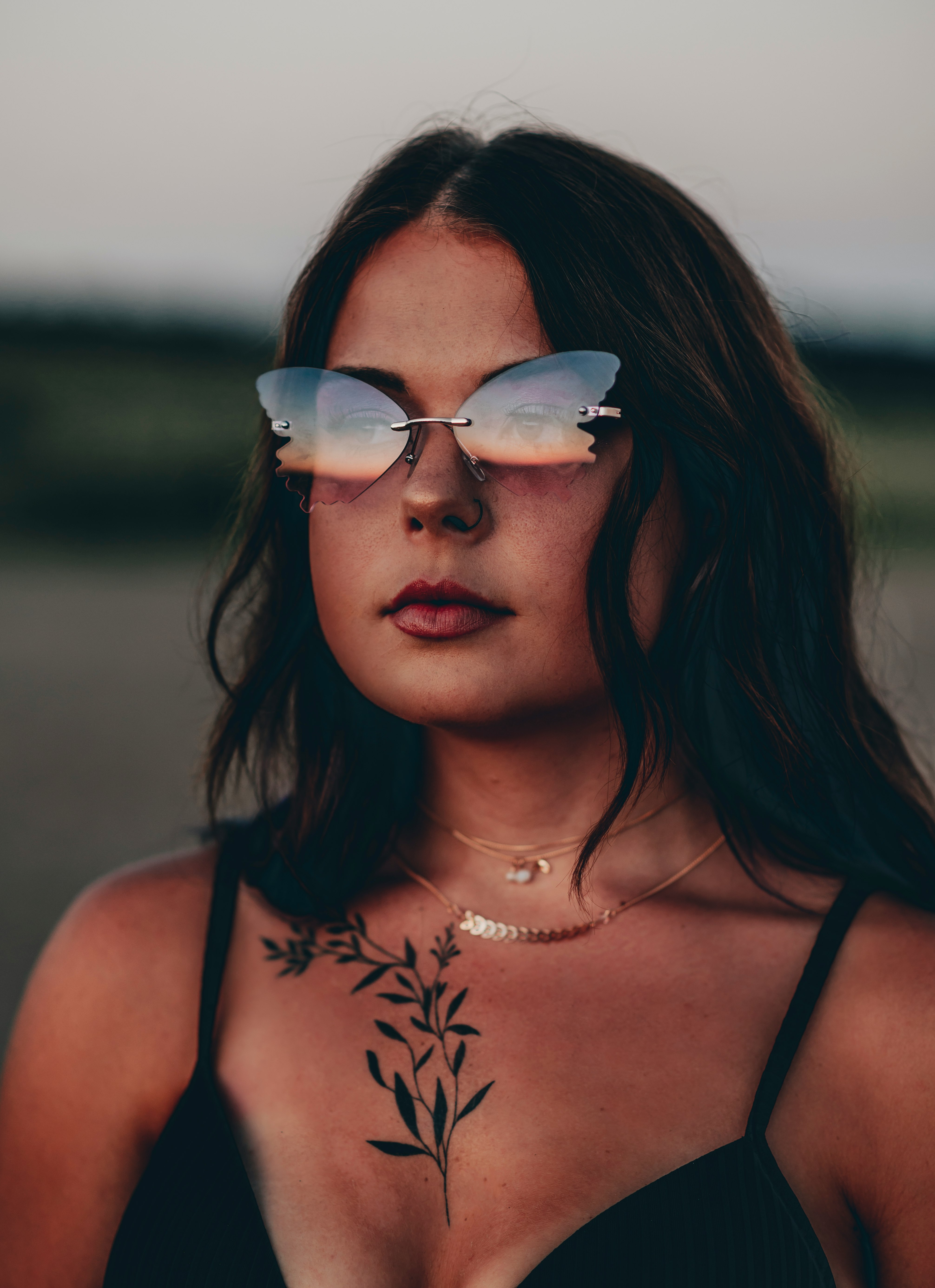 woman in black and white floral tank top wearing aviator sunglasses