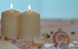 white pillar candles on brown and white floral textile