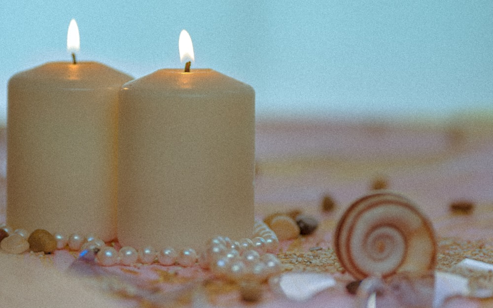 white pillar candles on brown and white floral textile