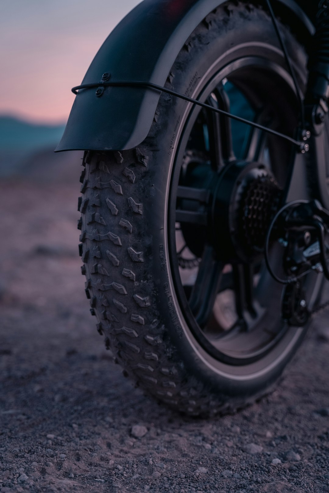 black motorcycle wheel on gray sand during daytime