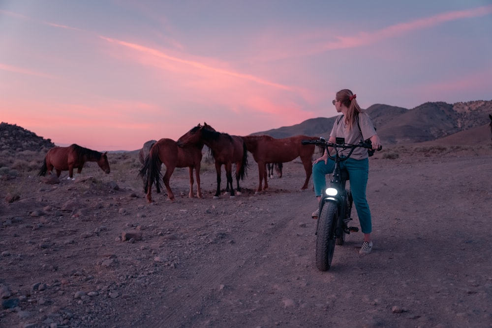 woman in blue jacket riding on brown horse during daytime