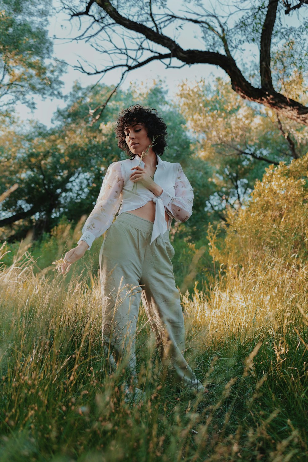 man in white dress shirt and brown pants standing on green grass field during daytime