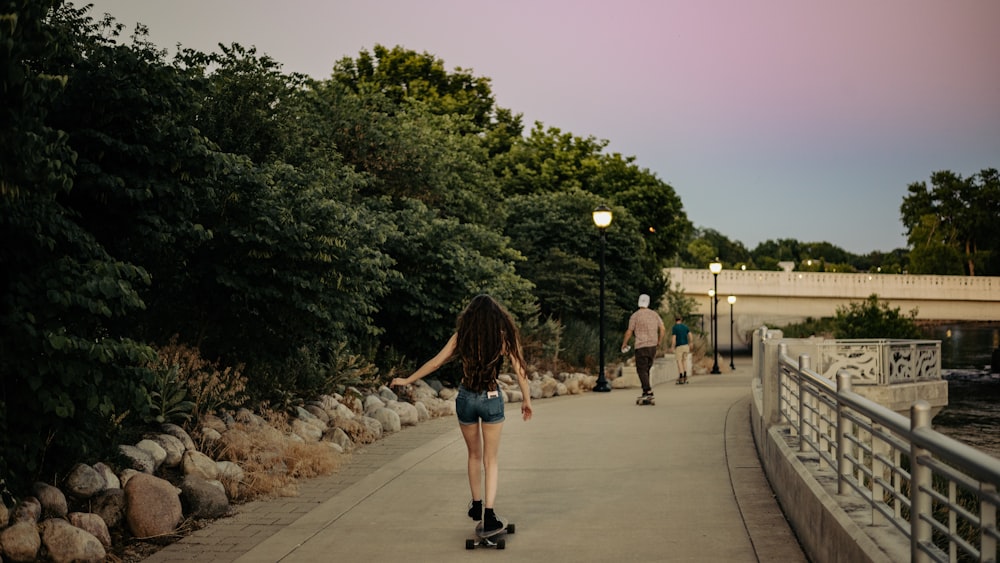 woman in blue denim shorts walking on sidewalk during daytime