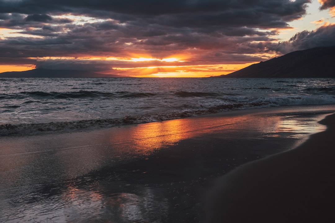 sea waves crashing on shore during sunset