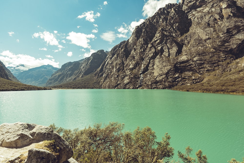 lake near mountain under blue sky during daytime