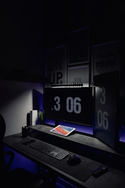 Dark-themed office workspace with computer screens showing data analytics dashboards.