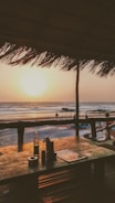 brown wooden dock on beach during sunset