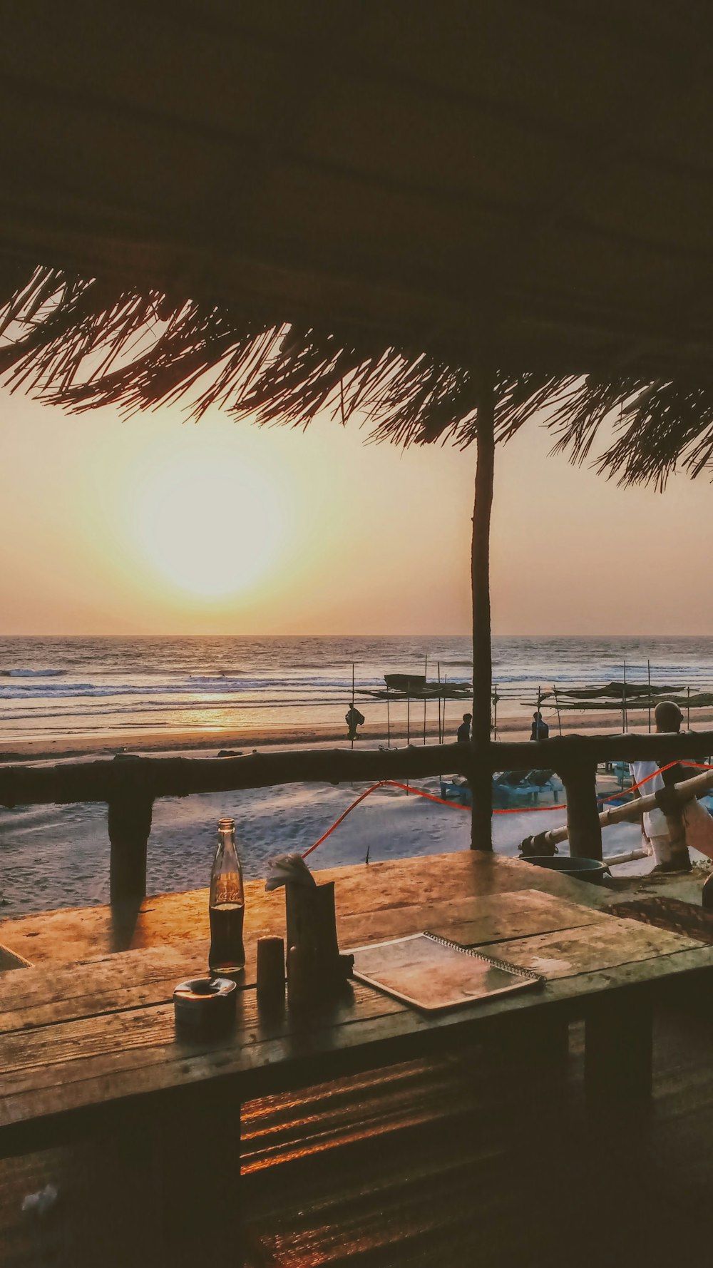 brown wooden dock on beach during sunset