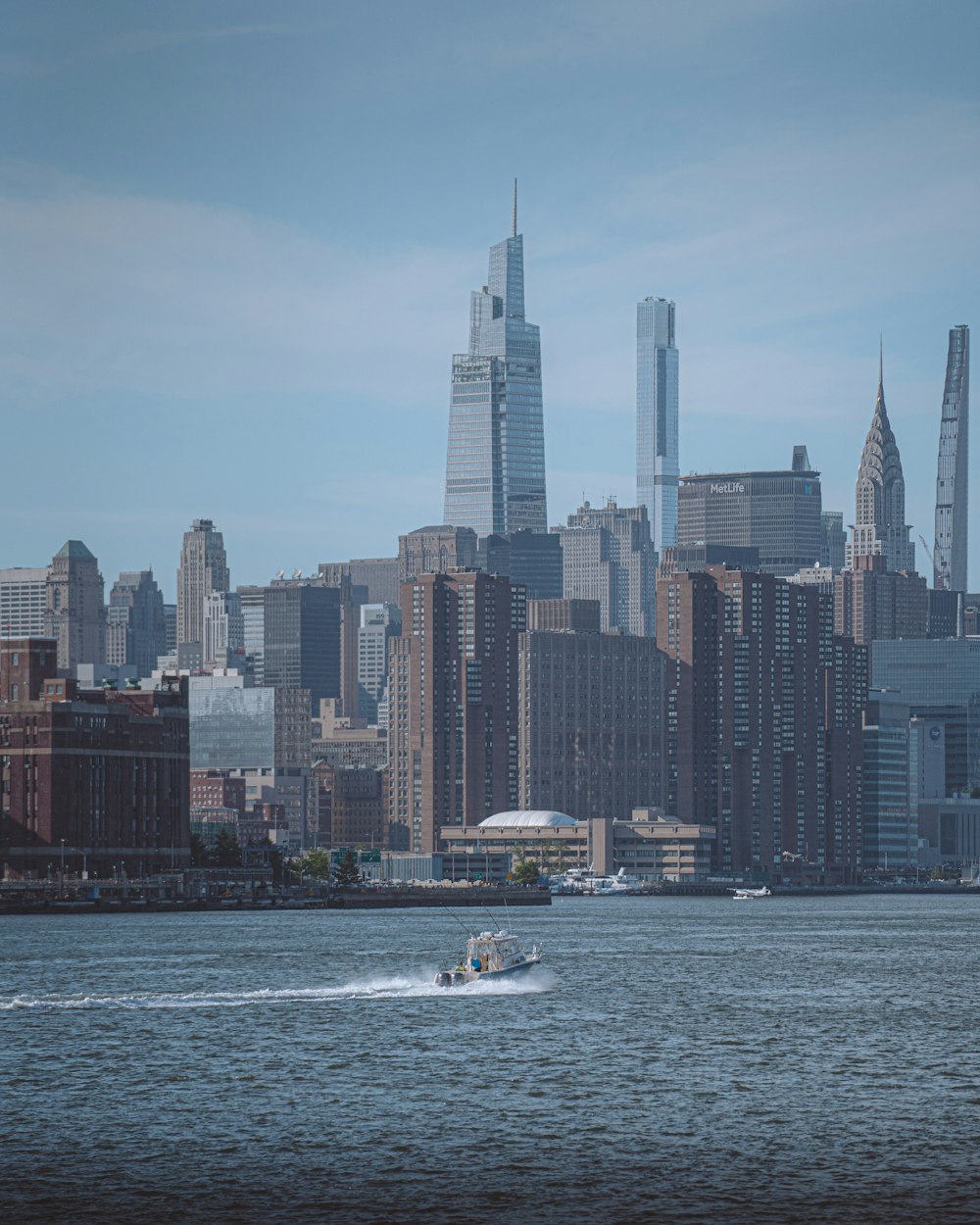 white boat on sea near city buildings during daytime