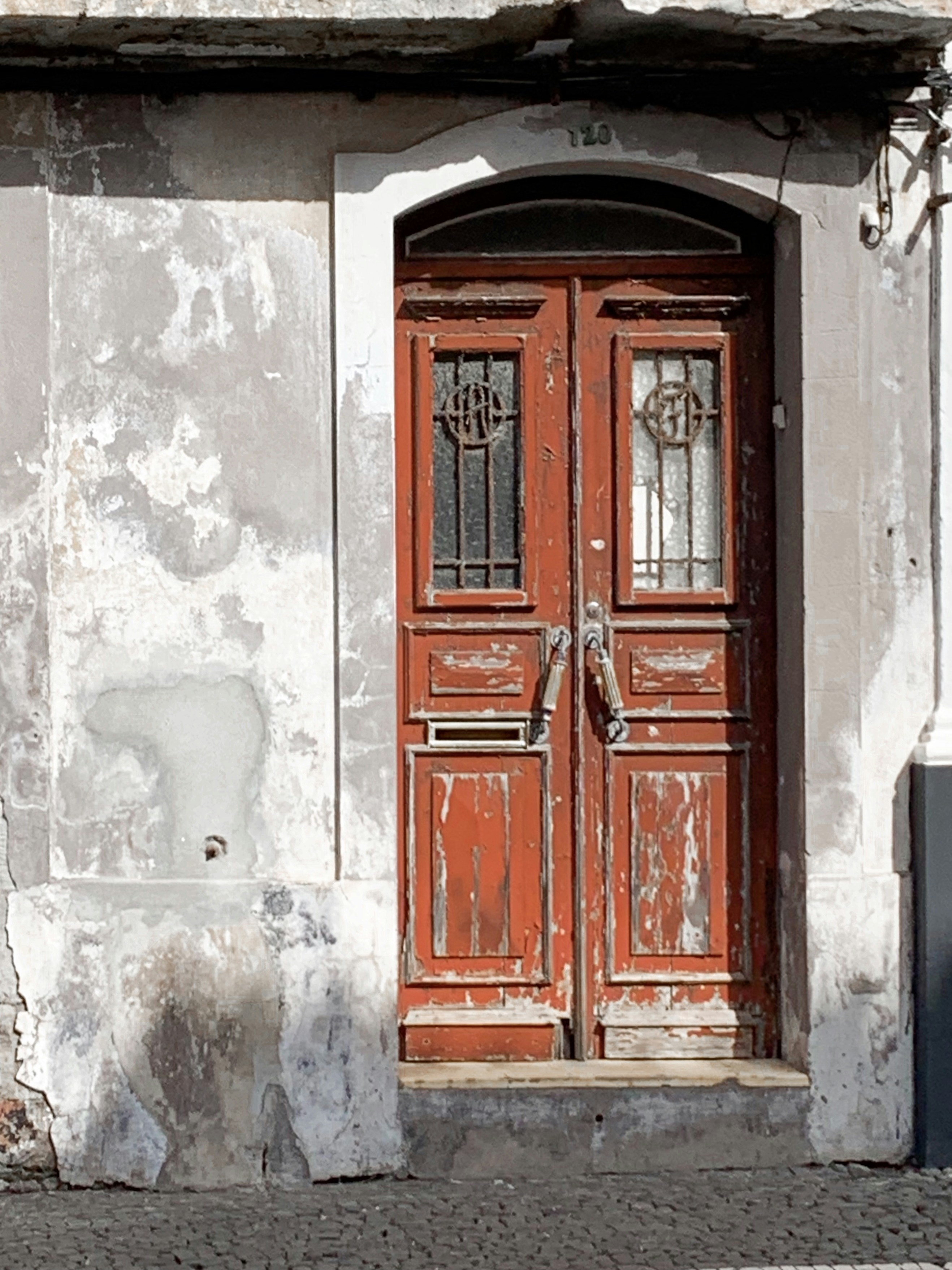 brown wooden door on white concrete wall