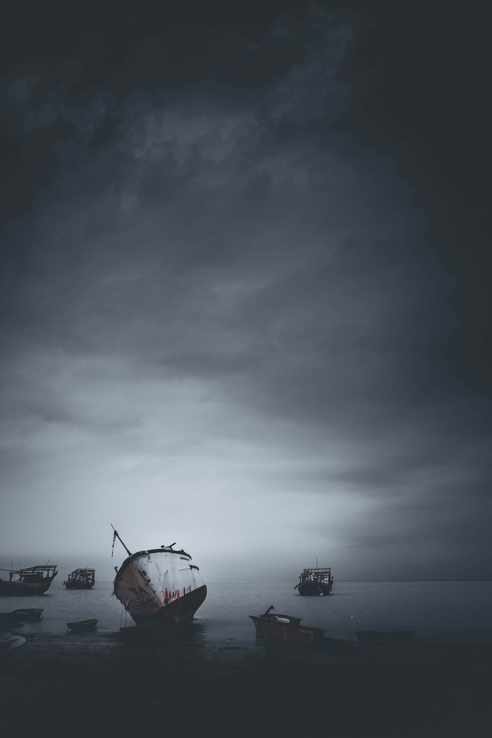 red and white boat on sea under gray sky