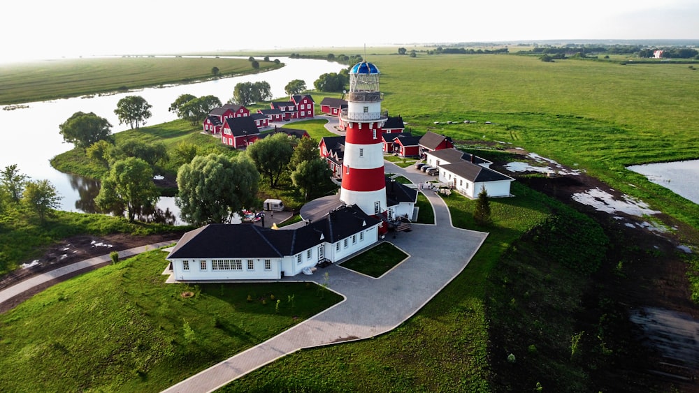 white and red lighthouse surrounded by green trees during daytime