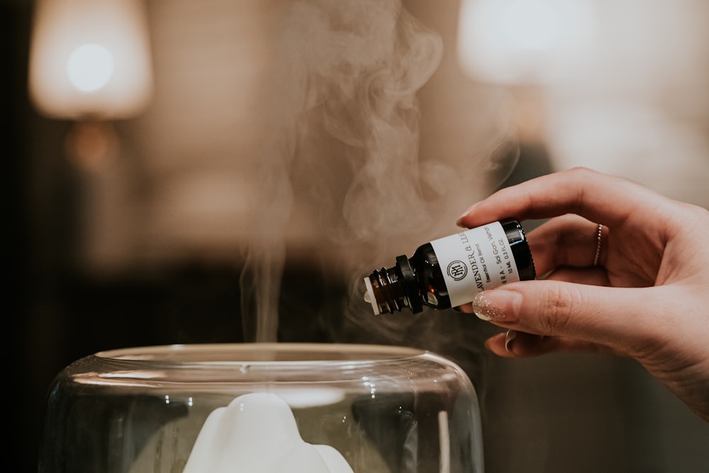 person holding black and white labeled bottle