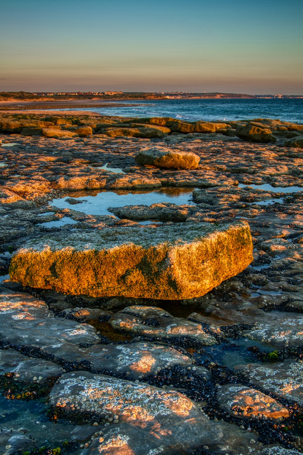 brown and gray rock formation on body of water during daytime