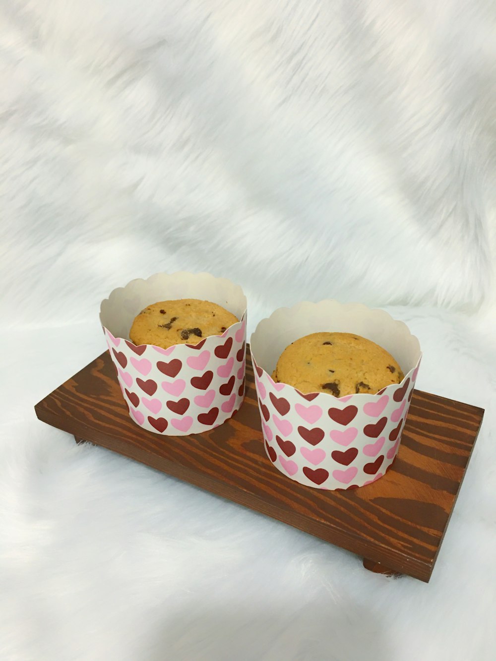 white and brown polka dot cupcakes on brown wooden tray