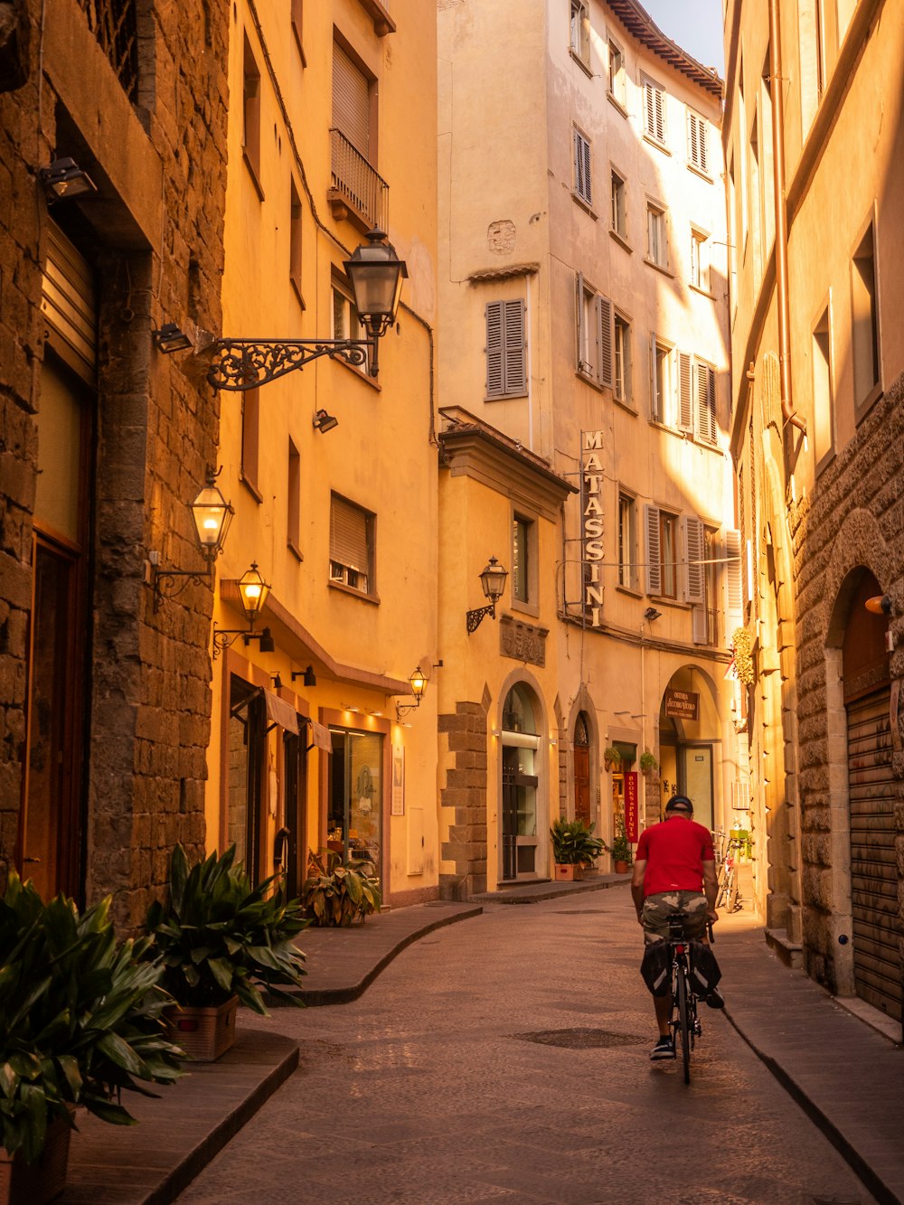 person in red jacket riding bicycle on road during daytime