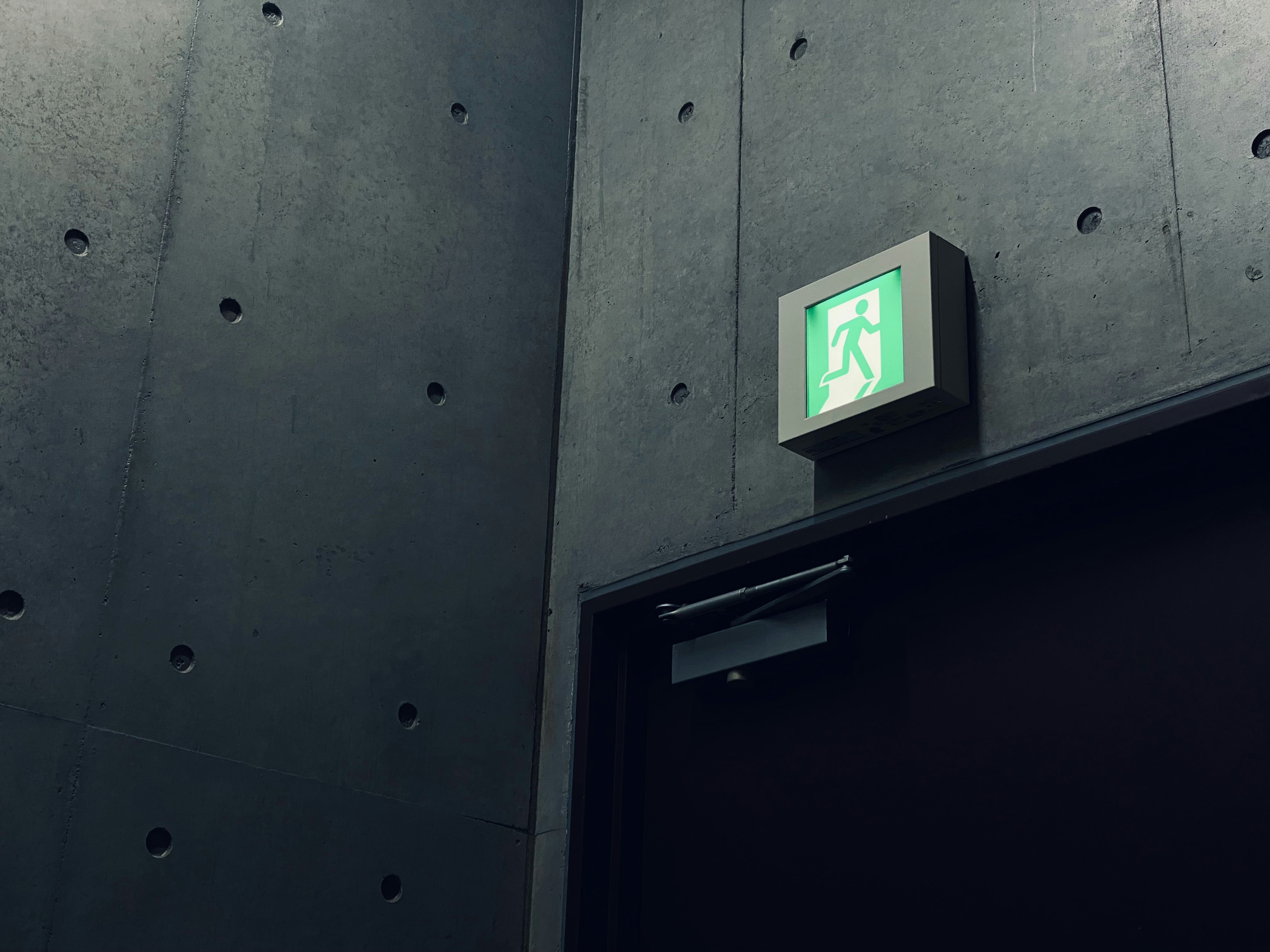Green and white emergency exit sign