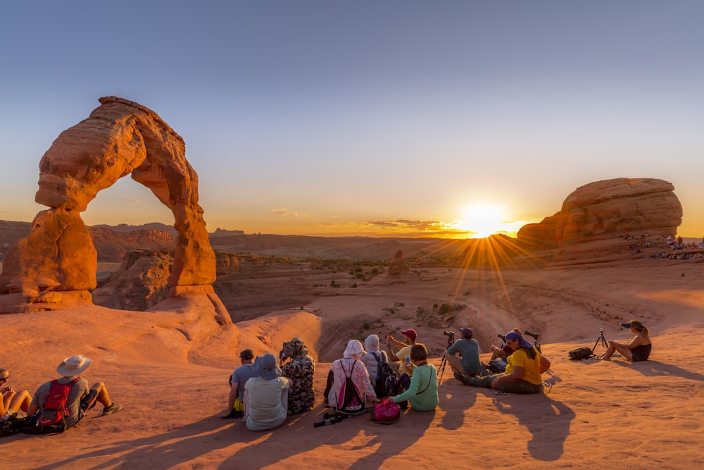 people sitting on brown sand during daytime