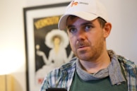 man in white fitted cap and green and white plaid shirt