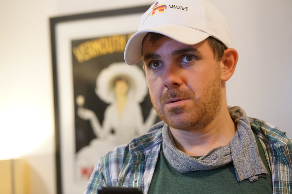 man in white fitted cap and green and white plaid shirt