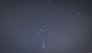 A serene night sky with the Orion constellation shining brightly above a calm landscape, symbolizing guidance and clarity.