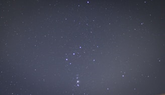 A clear night sky filled with stars. The constellation Orion is prominently visible with its distinct arrangement of bright stars.