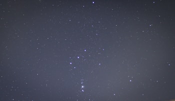 A clear night sky filled with stars. The constellation Orion is prominently visible with its distinct arrangement of bright stars.