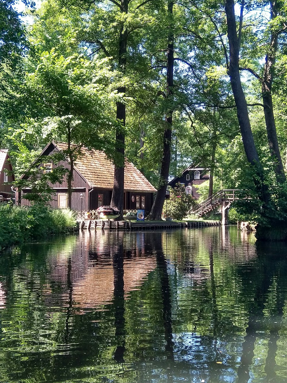 brown wooden house on river during daytime