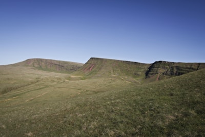 A wide open plot of land with clear blue skies and gentle rolling hills.