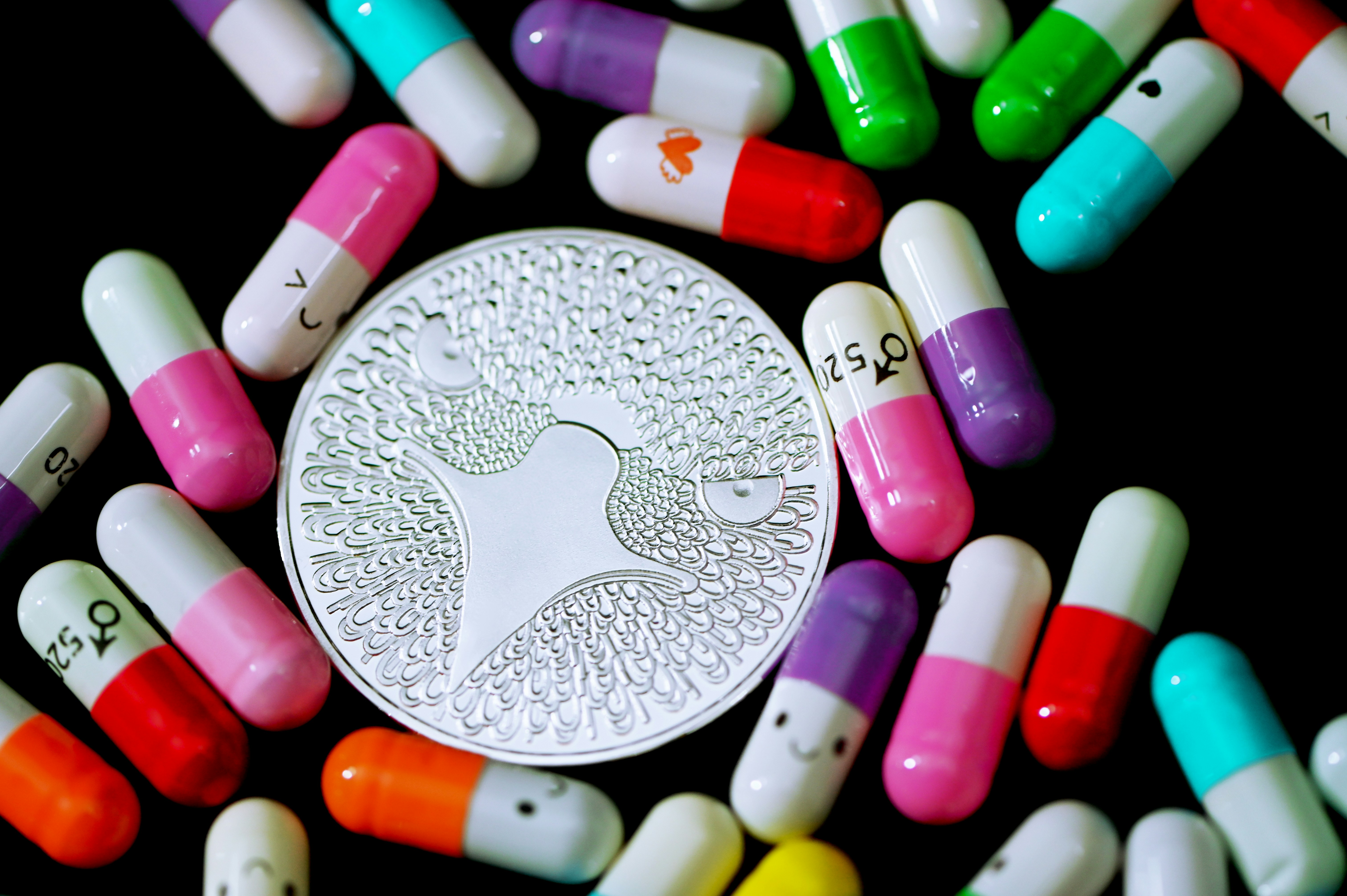 An Eagle coin surrounded by happy colorful pills