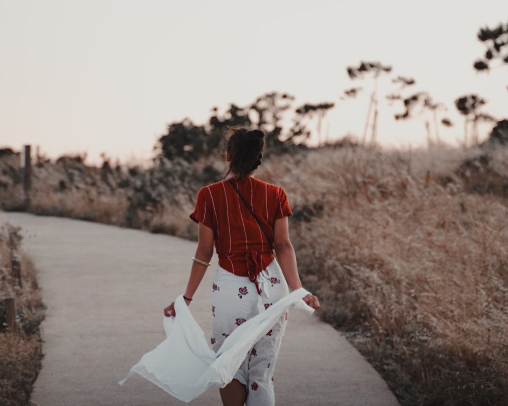 man in red and black polo shirt holding white plastic bag