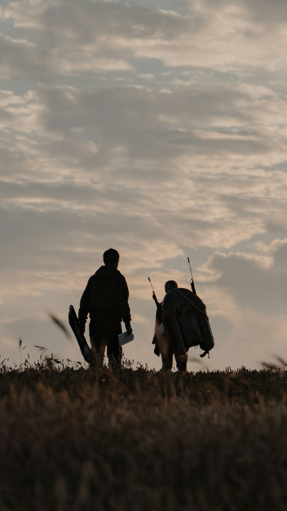 homme et femme marchant sur le champ d’herbe pendant la journée