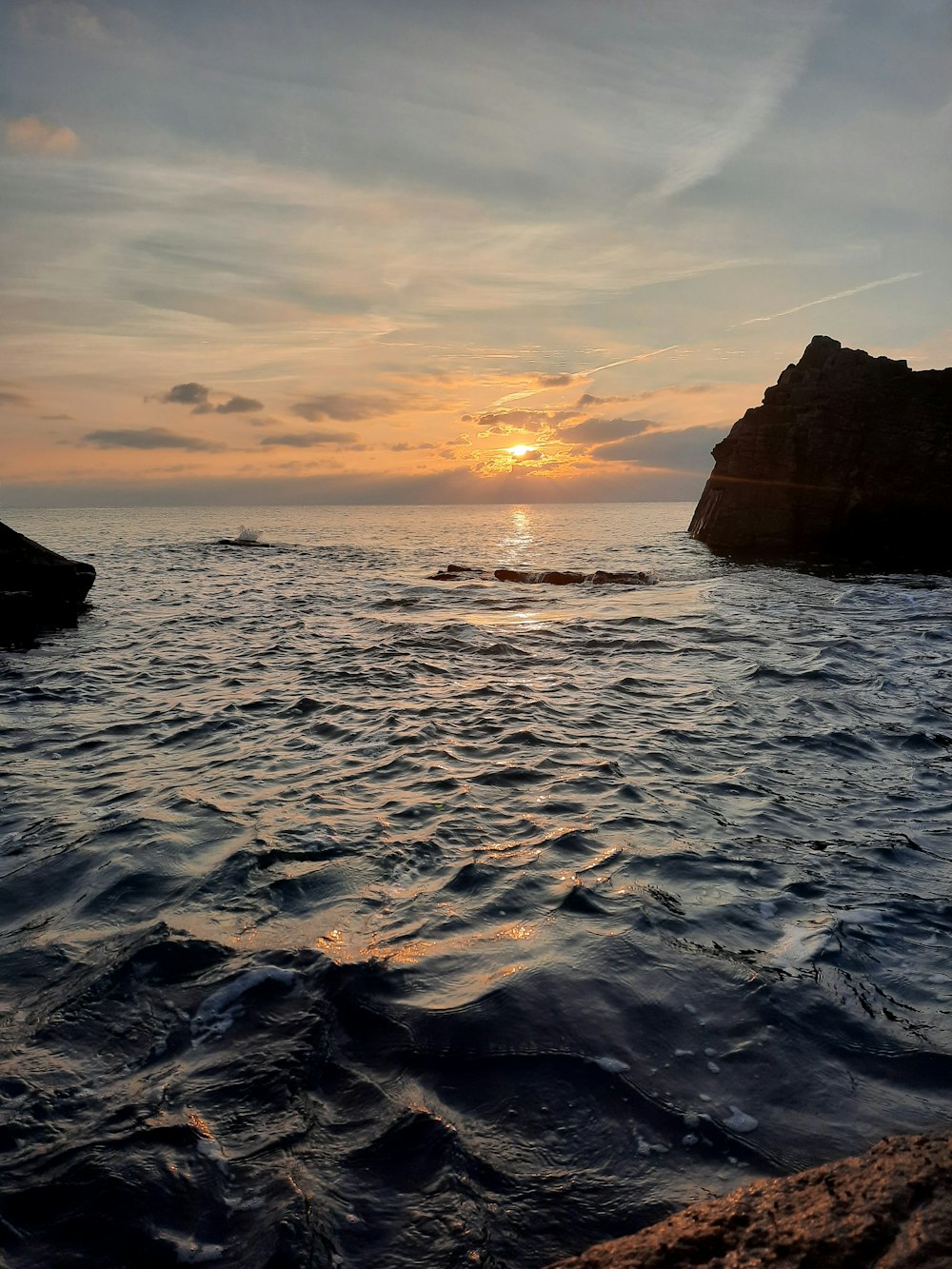 Formation rocheuse brune sur la mer au coucher du soleil