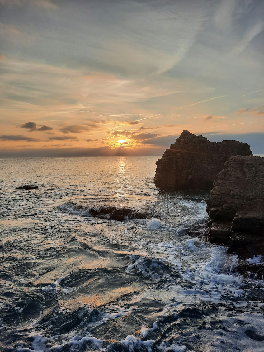 ocean waves crashing on rocks during sunset