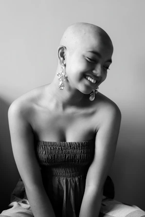 woman in tube dress and no hair smiling