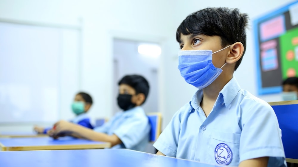 boy in white button up shirt wearing white face mask