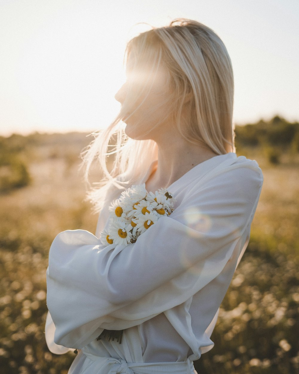 Femme en chemise blanche à manches longues avec une fleur blanche sur l’oreille
