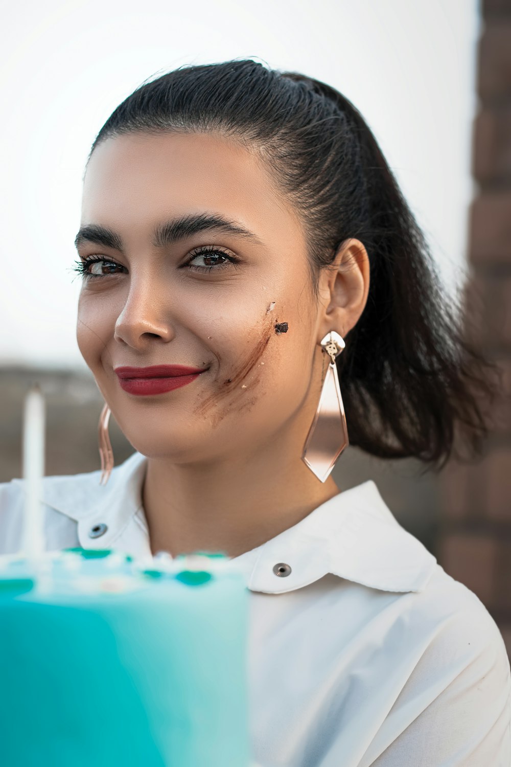 woman in white collared shirt with silver earrings