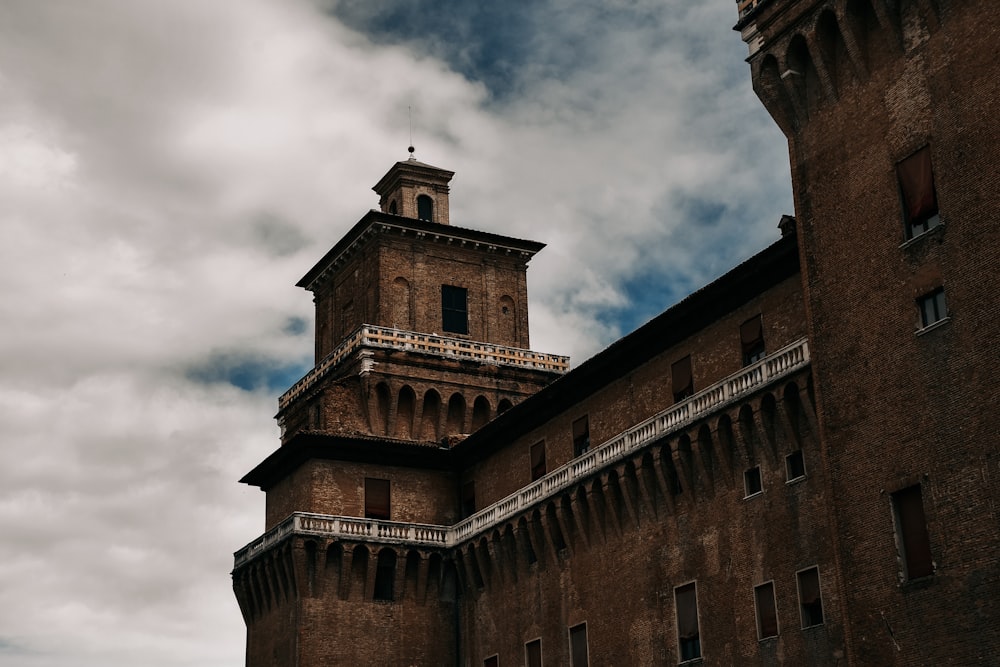 edificio in cemento marrone sotto il cielo nuvoloso durante il giorno