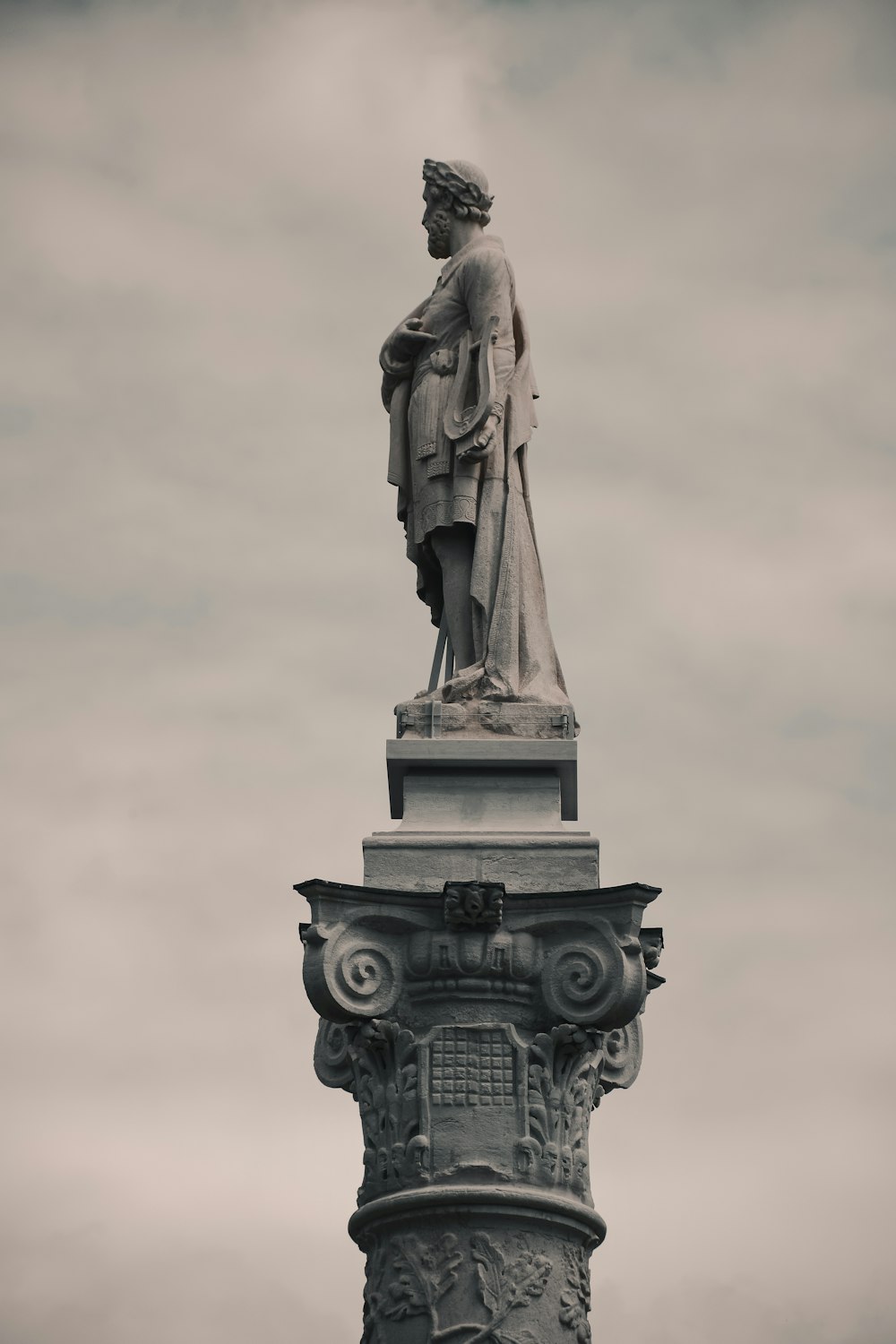 statue of man holding book