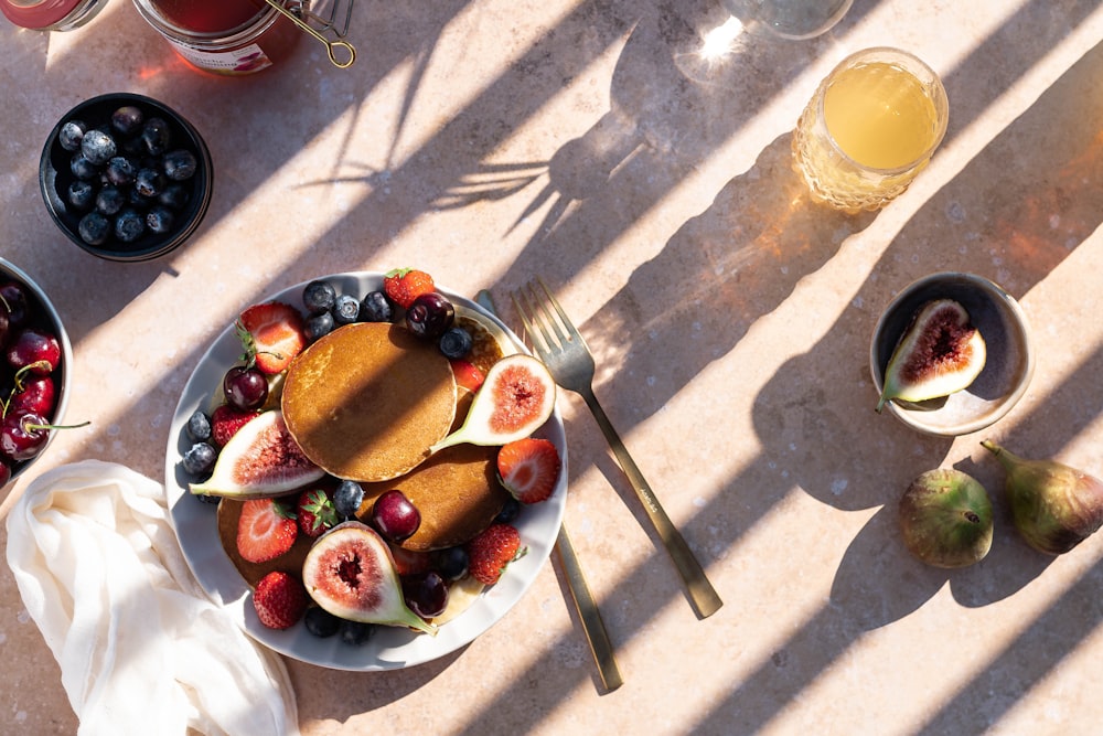 sliced strawberries and blueberries on white ceramic bowl