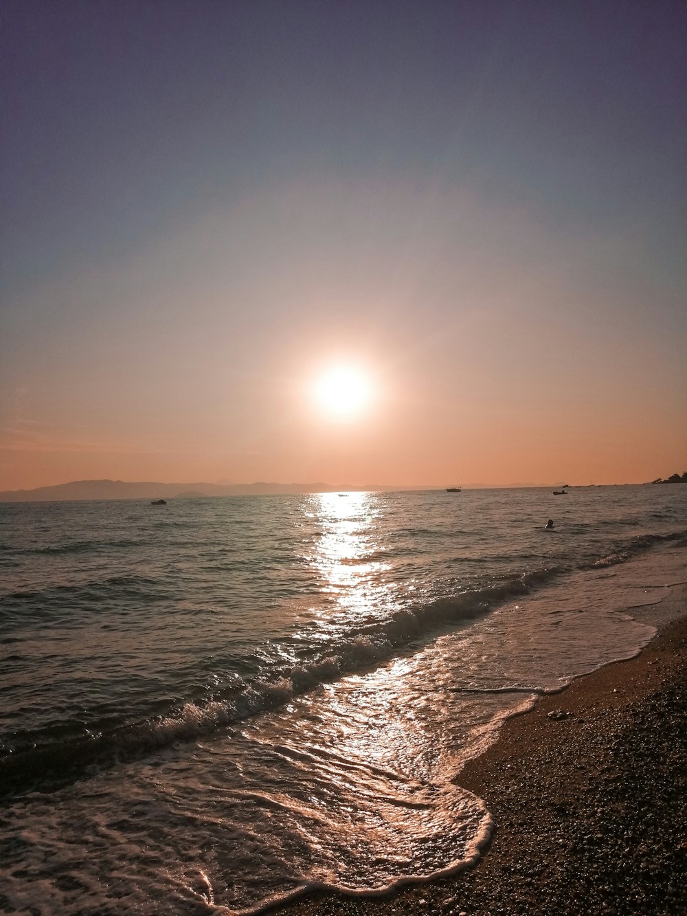 sea waves crashing on shore during sunset