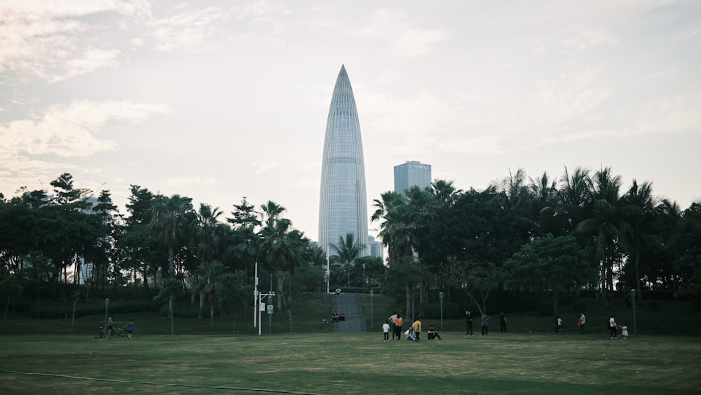 people walking on green grass field near white building during daytime